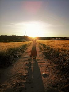 Imagen de mujer caminando al atardecer en la naturaleza, representando equilibrio hormonal y conexión con el cuerpo