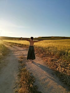 Mujer disfrutando de la naturaleza descalza, conectando con su cuerpo y promoviendo el equilibrio hormonal femenino