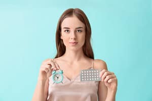 Mujer con pastillas anticonceptivas y reloj, ilustración sobre planificación, fertilidad y salud femenina
