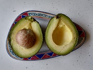 Mitad de aguacate partido en dos, ingrediente de receta para la regulación hormonal natural