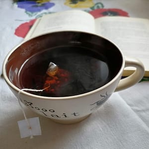 Infusión caliente junto a un libro, momento de autocuidado y relajación durante el ciclo menstrual